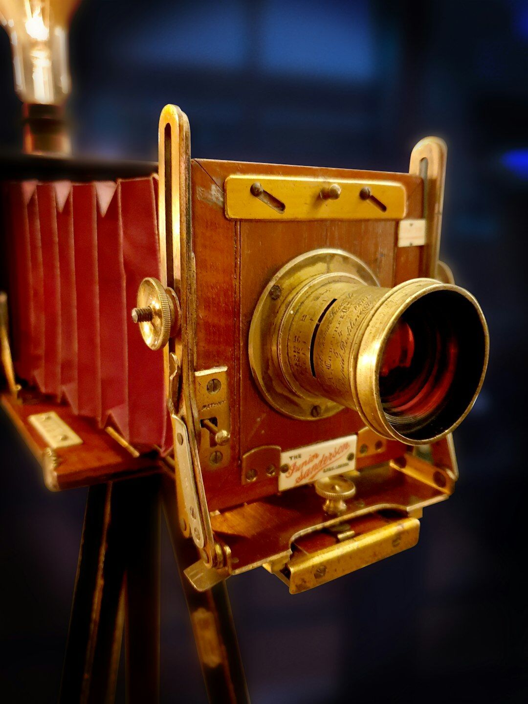 Vintage television studio camera on a tripod under warm studio lights